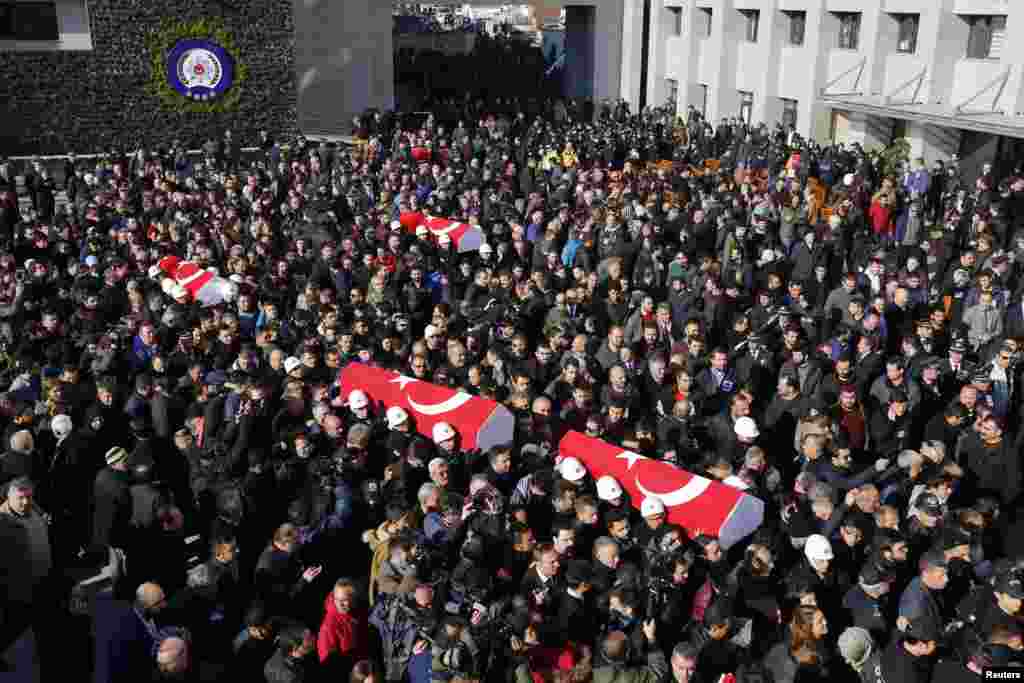 People carry the flag-draped coffins of police officers killed in Saturday's blasts in Istanbul, Turkey, Dec. 11, 2016.
