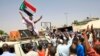 Des manifestants soudanais, brandissant le drapeau national, participent à un sit-in devant le quartier général de l'armée à Khartoum, le 5 mai 2019.