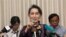 Myanmar opposition leader Aung San Suu Kyi, center, talks to journalists during a news conference at her residence, Saturday, July 11, 2015.
