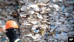 FILE - A container is filled with plastic waste from Australia, in Port Klang, Malaysia, May 28, 2019.