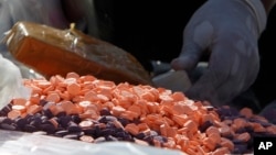 FILE PHOTO - A Cambodian drug expert prepares drug pills during a ceremony to mark the International Day Against Drug Abuse and Illicit Trafficking, in Phnom Penh, Cambodia, Tuesday, June 26, 2018. 