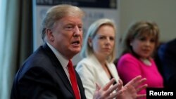 President Donald Trump speaks during a discussion of "fighting human trafficking on the southern border" with Homeland Security Secretary Kirstjen Nielsen, center, and International Network of Hearts President Alma Tucker at the White House in Washington, Feb. 1, 2019.