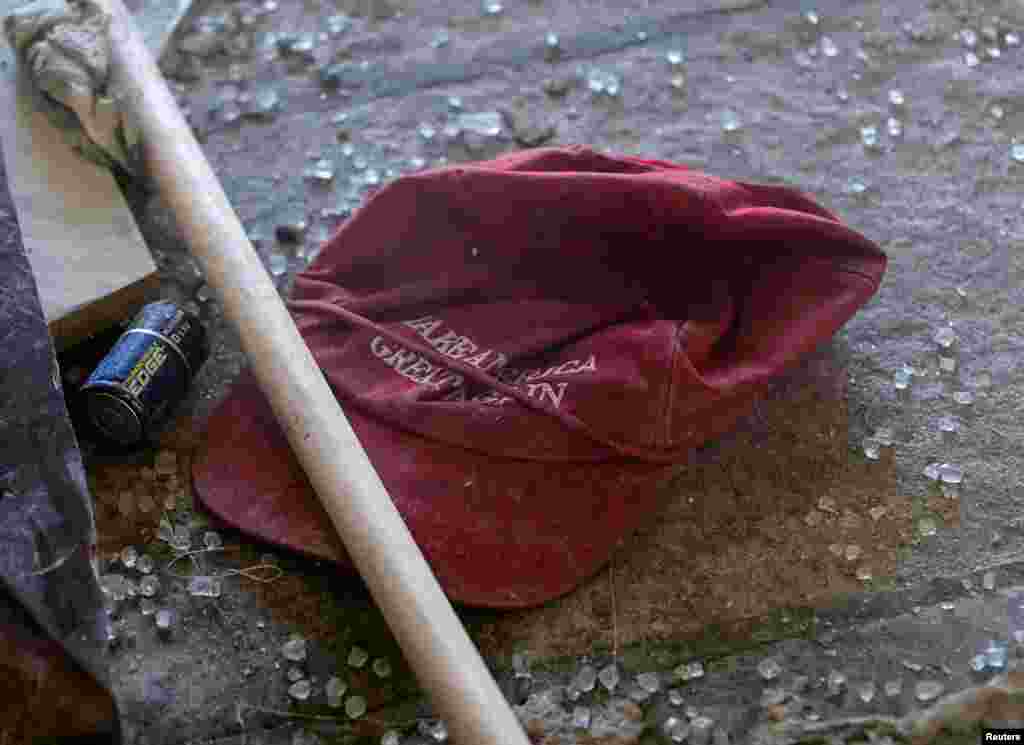 Entre los escombros reposa una gorra con el lema de campaña del presidente Trump "Hagamos América grande de nuevo"