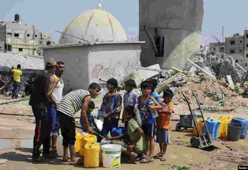 Children collect water during a five-day truce in Khan Younis in the southern Gaza Strip, Aug. 14, 2014.