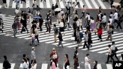 People wearing a protective face mask to help curb the spread of the coronavirus walk at Shibuya pedestrian crossing Thursday, July 9, 2020, in Tokyo. 