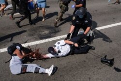 A Black Lives Matter protester and NYPD officers scuffle on the Brooklyn Bridge during a demonstration, in New York, July 15, 2020.