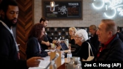 In this February 19, 2019 photo, a group of seniors from Laguna Woods Village consult with sales associates at Bud and Bloom cannabis dispensary in Santa Ana, California.