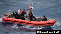 Petugas Garda Pantai AS saat mengevakuasi korban kecelakaan kapal di perairan Key West, Florida 7 Juli 2021. (Foto: U.S. Coast Guard via AP)