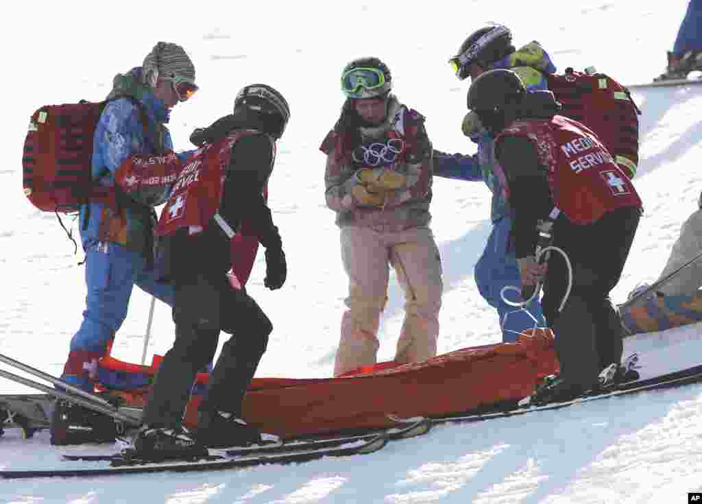United States' Arielle Gold is assisted after injuring her hand in a crash during the women's snowboard halfpipe warm-up, Feb. 12, 2014, in Krasnaya Polyana, Russia.