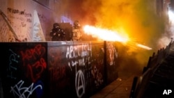 Federalni agenti pokušavaju da rasteraju demonstrante ispred sudnice u Portlandu, 19. jul 2020. (Foto: AP)