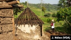 រូបឯកសារ៖ ស្រ្តីម្នាក់បីក្អមដើរកាត់ផ្ទះមួយនៅប្រទេសកេនយ៉ា។