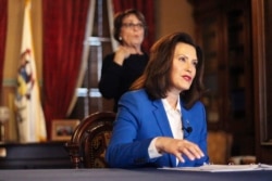 In a pool photo provided by the Michigan Office of the Governor, Gov. Gretchen Whitmer tells Michigan residents to stay at home, in her most sweeping order of the coronavirus crisis, March 23, 2020 in Lansing, Mich.