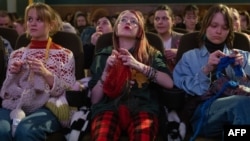 Women knit during the projection of the movie 'The Devil Wears Prada' at the Votive Cinema in Vienna, Austria, on February 16, 2025. (Photo by JOE KLAMAR / AFP)