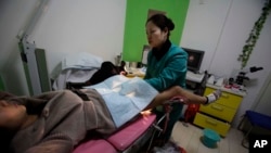 រូបភាពឯកសារ៖ គ្រូពេទ្យកំពុងពិនិត្យនាង "Nancy" Yin ដែលមានផ្ទៃពោះបីខែនៅគ្លីនិកពន្លូតកូន Marie Stopes International ប្រទេសចិន។