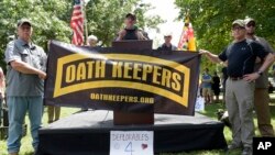 FILE - Stewart Rhodes, founder of the citizen militia group known as the Oath Keepers, center, speaks during a rally outside the White House in Washington, June 25, 2017. (AP Photo/Susan Walsh)