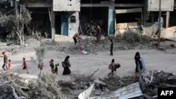 Palestinos caminan entre los escombros un día después de una operación israelí en Nuseirat, en el centro de la Franja de Gaza, el 9 de junio de 2024.