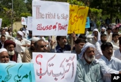FILE - Mohammad Idrees (foreground 2nd-R), father of accident victim Ateeq Baig, sits with people gathered at the spot where 22-year-old Baig was killed and another person injured when the U.S. military attaché Col. Joseph Emanuel Hall allegedly ran a red light and hit his motorcycle in Islamabad, Pakistan, April 13, 2018.