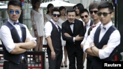 FILE - Ling Jueding (C) poses for a photo with his best men before his wedding ceremony at a park in Beijing, June 27, 2015.