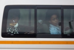FILE - Passengers sit inside a minibus taxi during their trip home, in Kwa-Thema, east of Johannesburg, South Africa, March 17, 2020.
