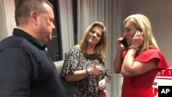 La ejecutiva de la construcción Marjorie Taylor Greene, a la derecha, mientras habla por teléfono, acompañada por partidarios, el martes 11 de agosto de 2020 en Roma, Georgia. 