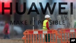 Workers clean the front of the new Huawei flagship store due to open soon in Madrid, Spain, May 22, 2019.