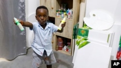 Ace-Liam Nana Sam Ankrah, who will turn two in July, shows off his paint tubes at his mother's art gallery in Accra, Ghana, Monday, May 27, 2024. (AP Photo/Misper Apawu)
