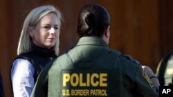 FILE - U.S. Department of Homeland Security Secretary Kirstjen Nielsen, left, speaks with Border Patrol agents near a newly fortified border wall structure, Oct. 26, 2018, in Calexico, Calif. 