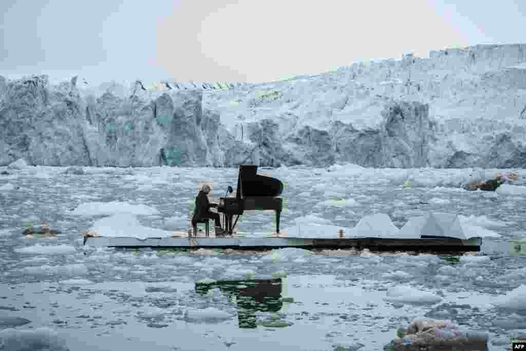 This handout picture released by Greenpeace shows Italian composer and pianist Ludovico Einaudi performing 'Elegy for the Arctic' on a floating platform in the Arctic Ocean on June 16, 2016, in front of the Wahlenbergbreen glacier in the archipelago Svalbard, near Ny-Alesund, Norway.