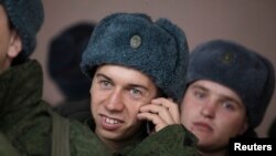 A conscript for the Russian army talks on a mobile phone at a recruiting station in Stavropol in southern Russia, October 20, 2010