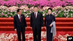 រូបឯកសារ៖ លោក​នាយក​រដ្ឋមន្ត្រី ហ៊ុន សែន (ឆ្វេង) អញ្ជើញ​ចូលរួម​ក្នុង​ពិធី​ទទួល​ស្វាគមន៍​មួយ​សម្រាប់​វេទិកា​ក្រវាត់​ផ្លូវ​ពាណិជ្ជកម្ម​របស់​ប្រធានាធិបតី​ចិន លោក Xi Jinping (កណ្ដាល) និង​អ្នកស្រី Peng Liyuan ជា​ភរិយា (ស្ដាំ) នៅ​ទីក្រុង​ប៉េកាំង ប្រទេស​ចិន ថ្ងៃទី២៦ ខែមេសា ឆ្នាំ២០១៩។ 