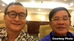A widely shared photo on Cambodian social media, Cambodian opposition leader Sam Rainsy and Prime Minister Hun Sen take a selfie to affirm their culture of dialogue at a dinner between the two families at Cambodiana Hotel in Phnom Penh, Sunday, July 12, 2015. (Photo Courtesy)