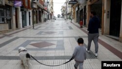 រូបឯកសារ៖ កុមារម្នាក់បណ្តើរសុនខដើរជាមួយឪពុកនៅផ្លូវស្ងប់ស្ងាត់មួយ បន្ទាប់ពីមានការរាតត្បាតវីរុសកូរ៉ូណា នៅក្រុង Ronda ប្រទេសអេស្ប៉ាញ កាលពីថ្ងៃទី២៦ ខែមេសា ឆ្នាំ២០២០។ 