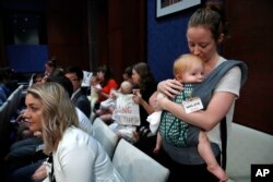 Mujeres con niños protestan en el Capitolio en Washington, el martes 19 de junio de 2018 contra la separación de familias de migrantes ilegales en la frontera.