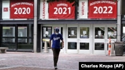 Weston Koenn, a graduate student from Los Angeles, leaves the Boston University student union building as he walks through the student-less campus, Thursday, July 23, 2020, in Boston. (AP Photo/Charles Krupa)