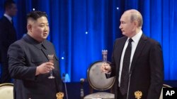 Russian President Vladimir Putin, right, toasts with North Korea's leader Kim Jong Un after their talks in Vladivostok, Russia, April 25, 2019. 