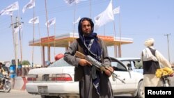 យុទ្ធជន​​ម្នាក់​របស់​ក្រុម​តាលីបង់​ឈរ​កាន់​កាំភ្លើង​នៅ​ទីក្រុង Ghazni ប្រទេស​អាហ្វហ្គានីស្ថាន ថ្ងៃទី១៤ ខែសីហា ឆ្នាំ២០២១។ 