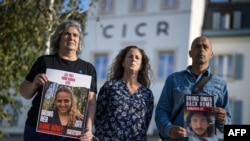 Mikal Dorset, ujna Romi Gonen, drži njenu sliku na skupu podrške porodicama talaca u Ženevi (foto: Fabrice COFFRINI / AFP)