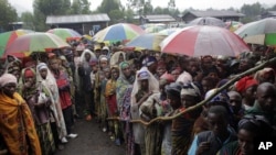 Internally displaced Congolese men and women wait for a World Food Program energy biscuits to be distributed in Kibati, north of Goma, eastern DRC, August 8, 2012.