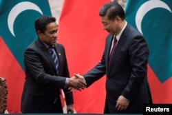 2017年12月7日，马尔代夫总统亚明在中国北京人民大会堂签署文件后，与中国国家主席习近平握手。