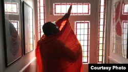 Luon Sovath puts on his saffron robes at Chris Kelly's apartment in London. (Chris Kelly)