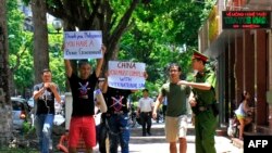 ប៉ូលិស​ម្នាក់​ (រូប​ស្តាំ) មាន​ប្រតិកម្ម​នៅ​ពេល​មាន​សកម្មជន​របស់​បាតុកម្ម​កាន់​បដា​ប្រឆាំង​នឹង​ចិន នៅ​ក្នុង​ក្រុង​ហាណូយ កាលពី​ថ្ងៃទី១៧ ខែកក្កដា ឆ្នាំ២០១៦។