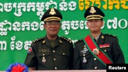FILE PHOTO: Cambodia's Prime Minister Hun Sen (L) poses with his son Hun Manet on the outskirts of Phnom Penh on October 13, 2009. REUTERS/Chor Sokunthea