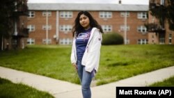 In this Friday, April 3, 2020 photo, Anali Reyes Vazquez a senior at Rutgers University–Camden senior poses for a photograph in Barrington, N.J. (AP Photo/Matt Rourke)