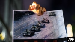 在香港維多利亞公園參加紀念六四事件31週年的一名男子手持天安門廣場“坦克人”的照片。 （法新社2020年6月4日）