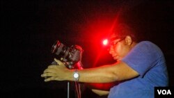 A photographer sets up his camera hoping to document the universal phenomenon of the Perseid Meteor Shower, in the Valley of Whales, in Fayoum, Egypt, Aug. 12, 2017. 