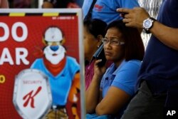 Workers wait for information about their jobs outside the Kellogg's factory in Maracay, Venezuela, May 15, 2018.