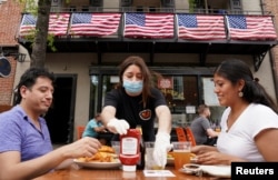 A waitress serves diners at a restaurant in Alexandria, Virginia, U.S., May 29, 2020. (REUTERS/Kevin Lamarque/File Photo)