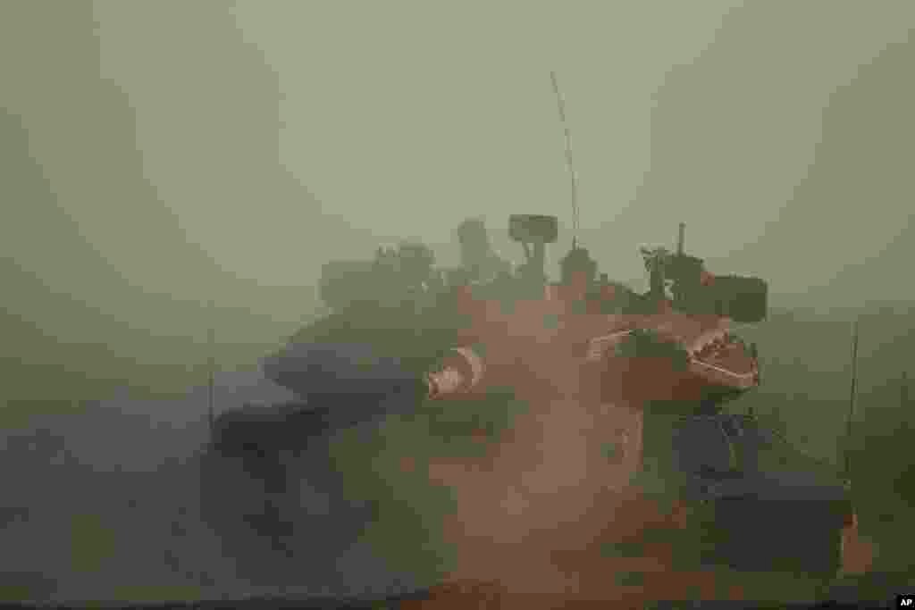 An Israeli tank takes its position along the Israel-Gaza border, July 17, 2014.