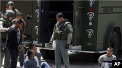 Foto Archivo - Sospechosos de inmigrantes indocumentados son detenidos por agentes de la ley en Phoenix después de allanar una casa jueves, 29 de abril de 2010.