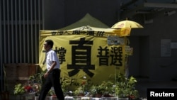 A security guard walks past a tent set up by pro-democracy protesters outside government headquarters in Hong Kong, China, June 16, 2015. 